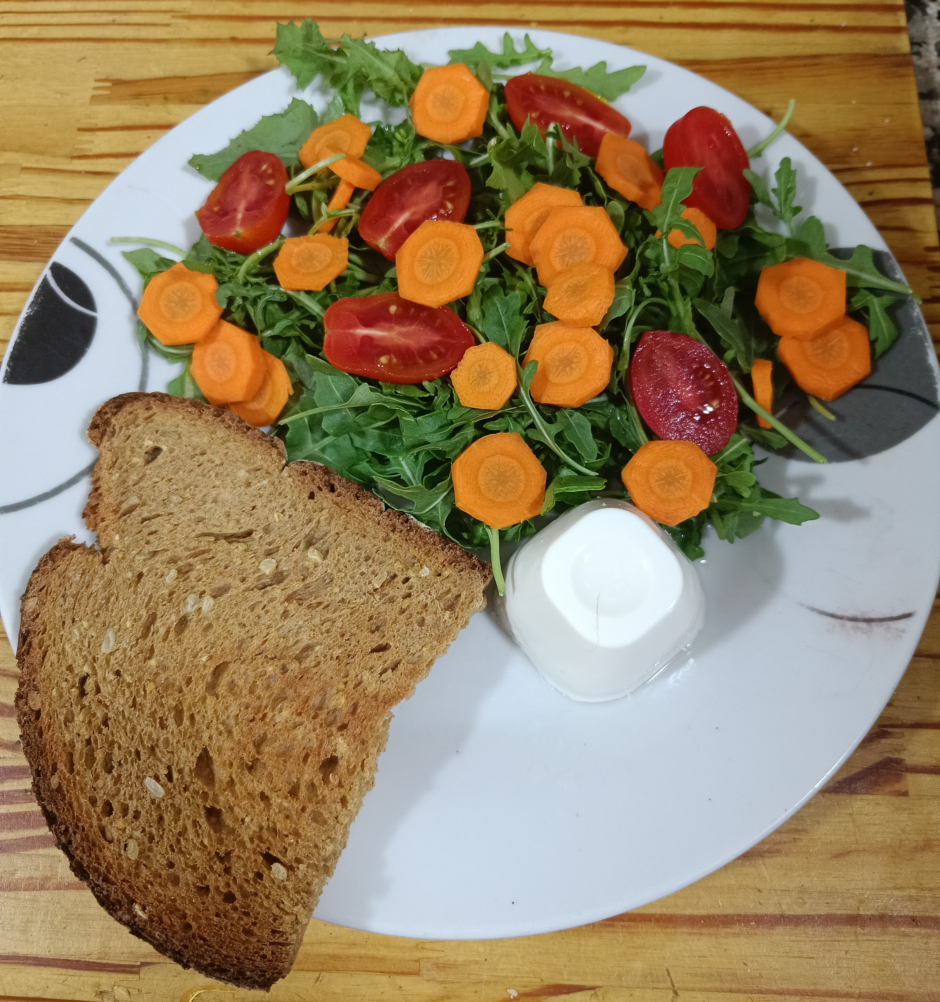 Imagen de Ensalada de rúcula con tomate cherry, zanahoria y queso fresco + pan integral